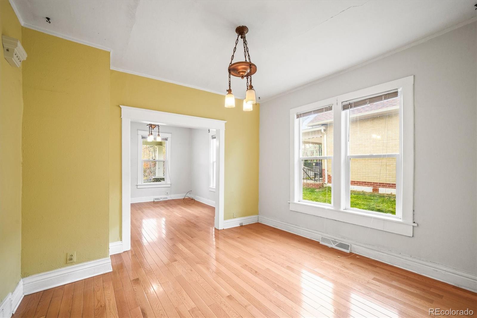 4551 Utica Street Denver, CO 80212 - Photo 9 of 32 a view of an empty room with wooden floor and a window