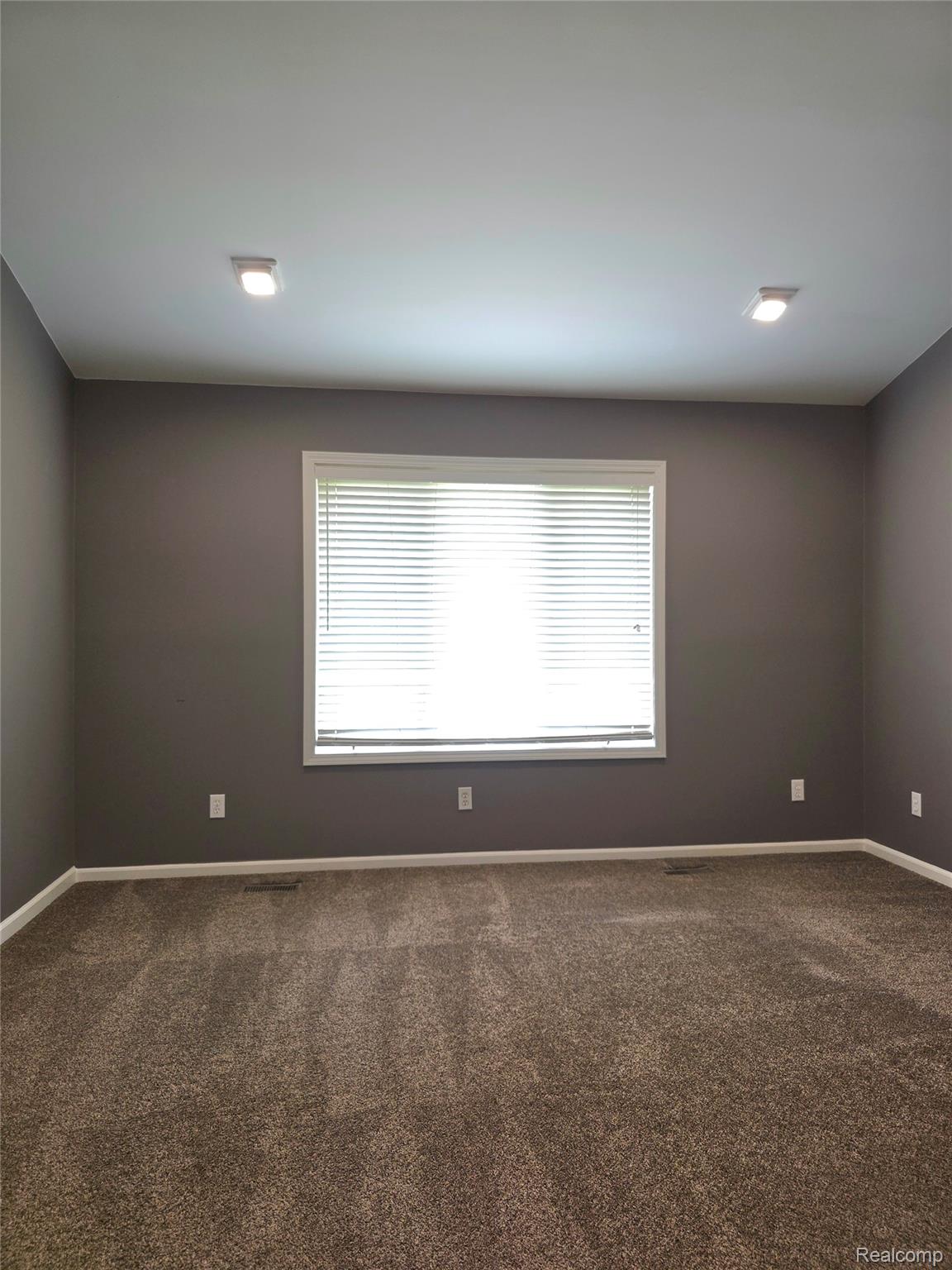 5158 Coldwater Road Columbiaville, MI 48421 - Photo 10 of 25 Bright room featuring a large window with blinds, recessed lighting, neutral-toned walls, and plush carpeting