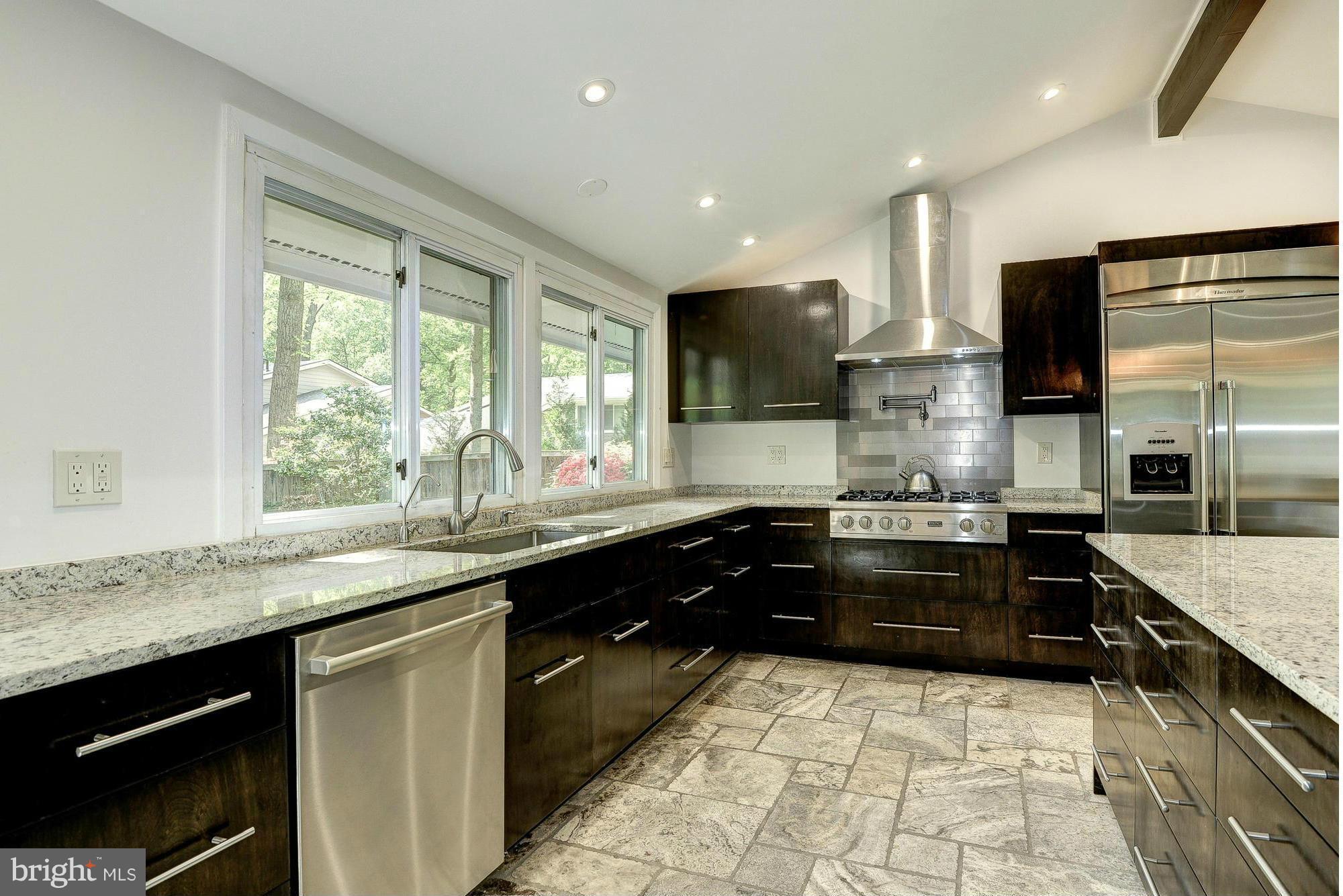6718 Persimmon Tree Road Bethesda, MD 20817 - Photo 11 of 30 a large kitchen with granite countertop a stove and a sink
