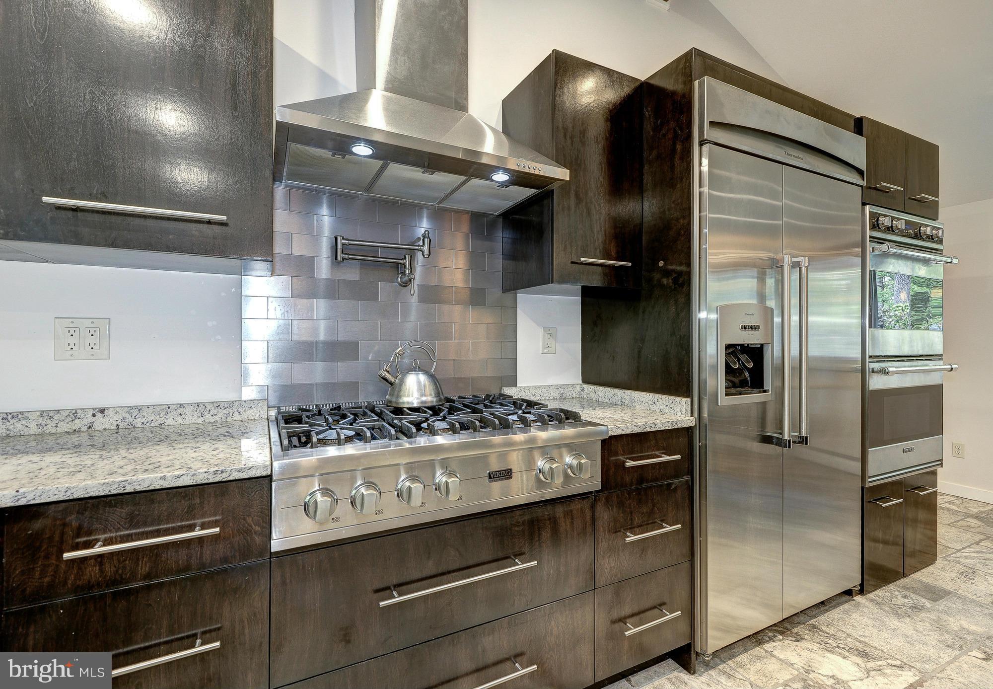 6718 Persimmon Tree Road Bethesda, MD 20817 - Photo 12 of 30 a kitchen with stainless steel appliances granite countertop a stove and a refrigerator