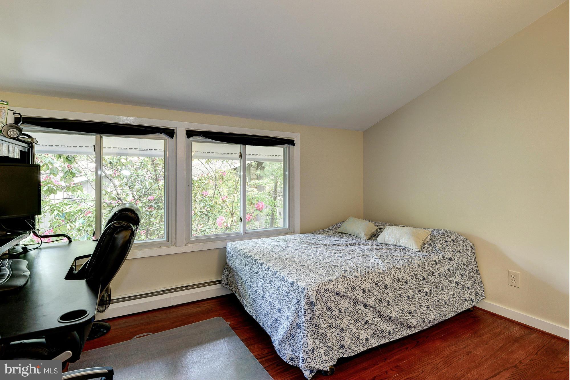 6718 Persimmon Tree Road Bethesda, MD 20817 - Photo 14 of 30 a bedroom with a bed a desk and large window