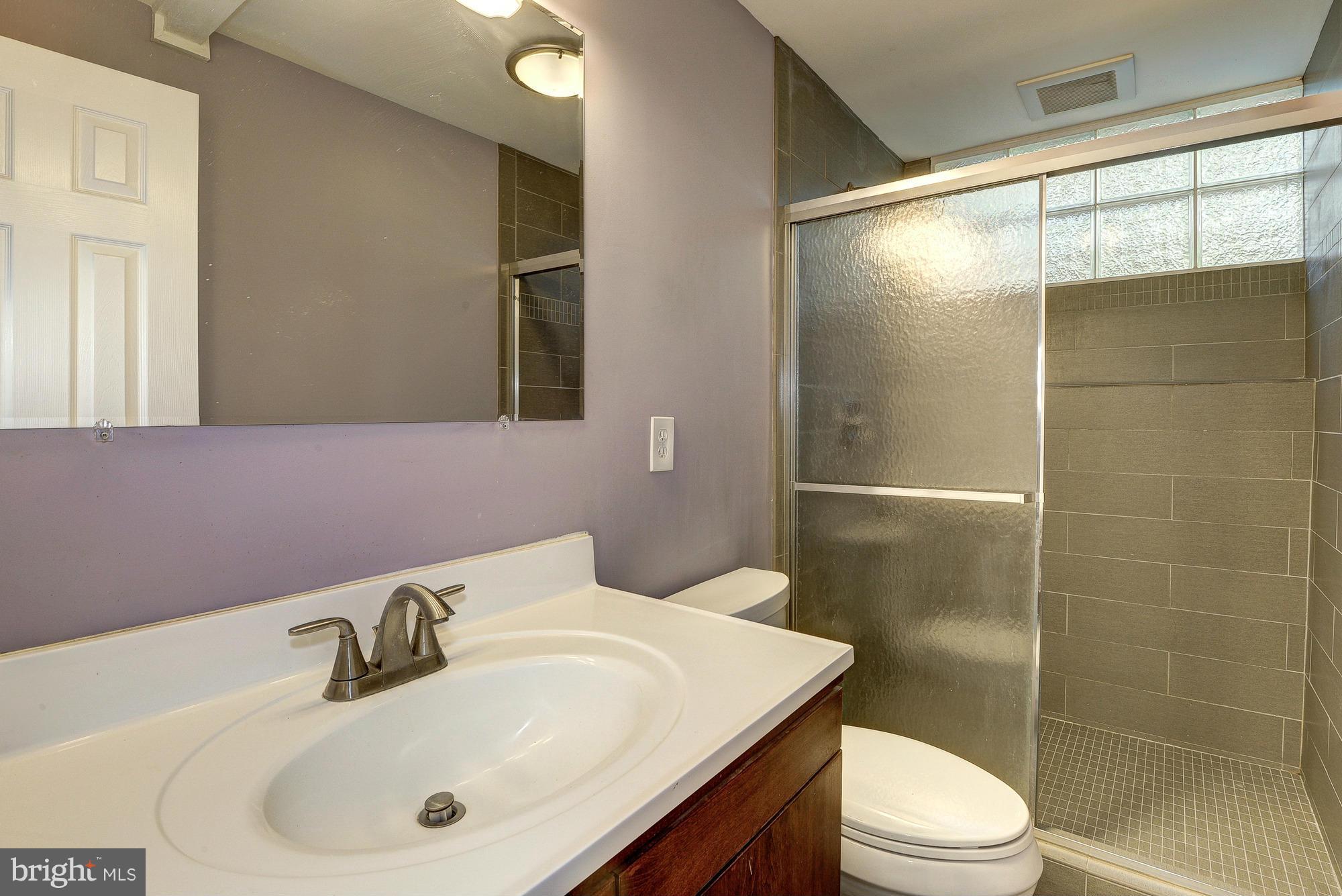6718 Persimmon Tree Road Bethesda, MD 20817 - Photo 15 of 30 a bathroom with a sink toilet and shower
