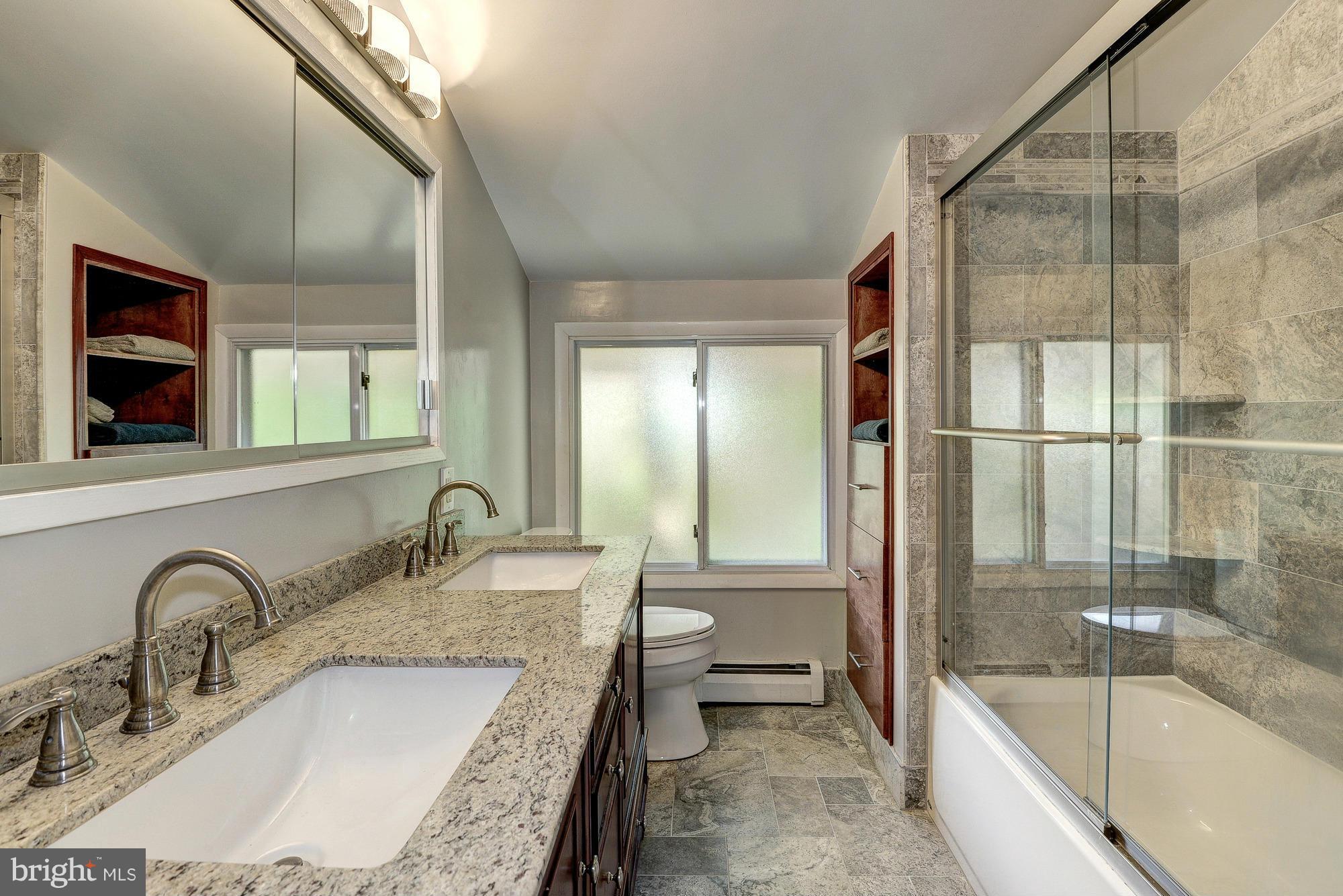 6718 Persimmon Tree Road Bethesda, MD 20817 - Photo 17 of 30 a bathroom with a granite countertop tub a sink and a large mirror