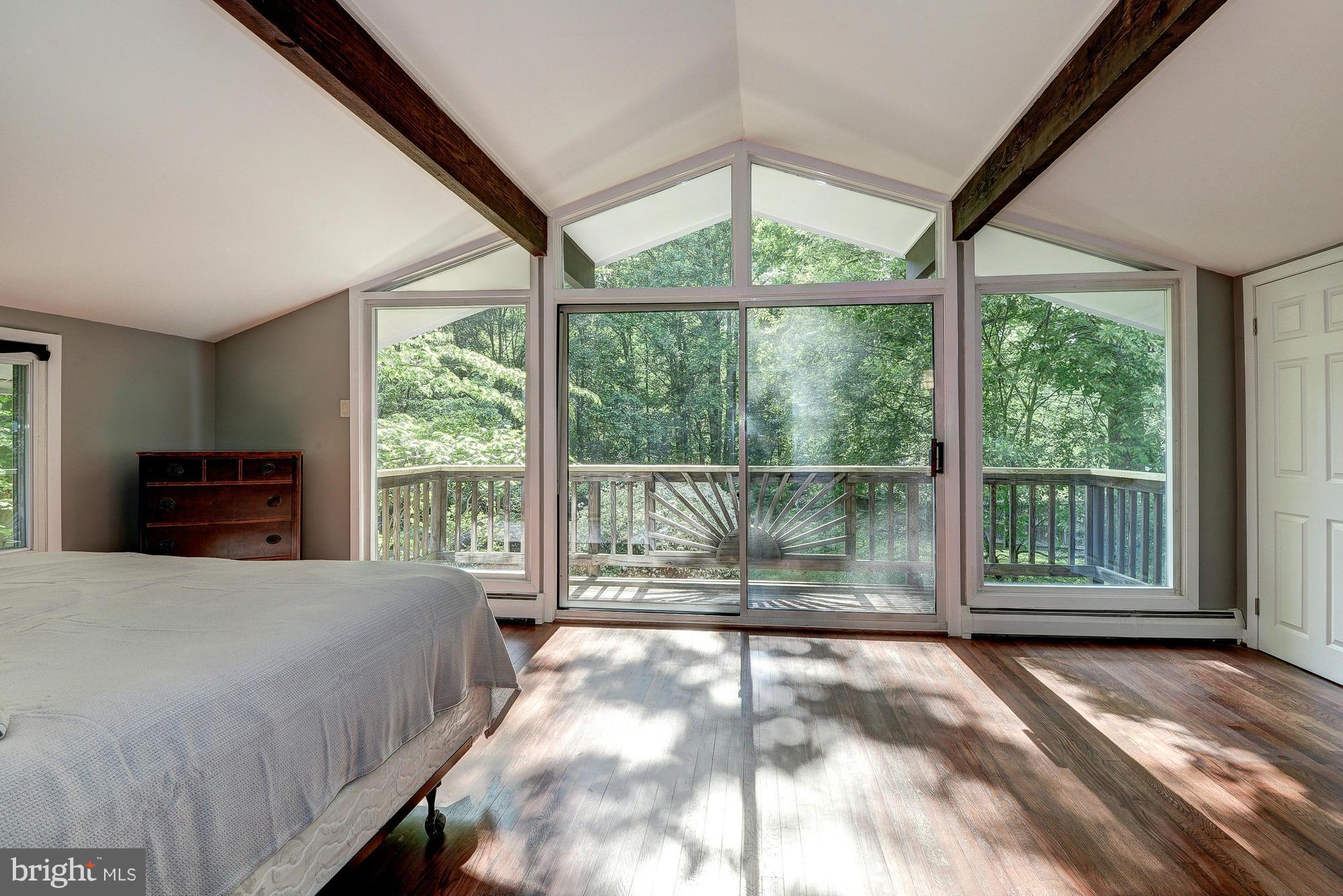 6718 Persimmon Tree Road Bethesda, MD 20817 - Photo 18 of 30 a bedroom with a large bed and a large window