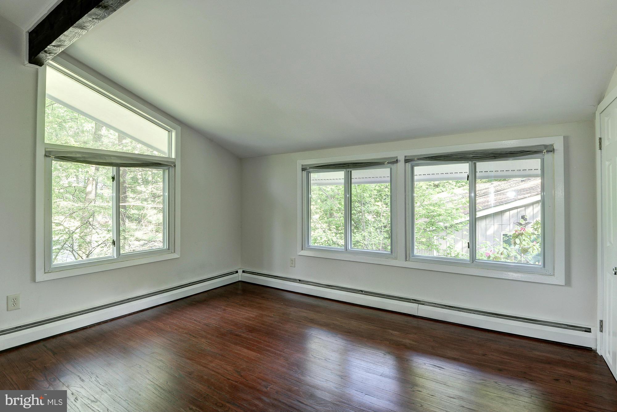 6718 Persimmon Tree Road Bethesda, MD 20817 - Photo 21 of 30 a view of an empty room with wooden floor and a window