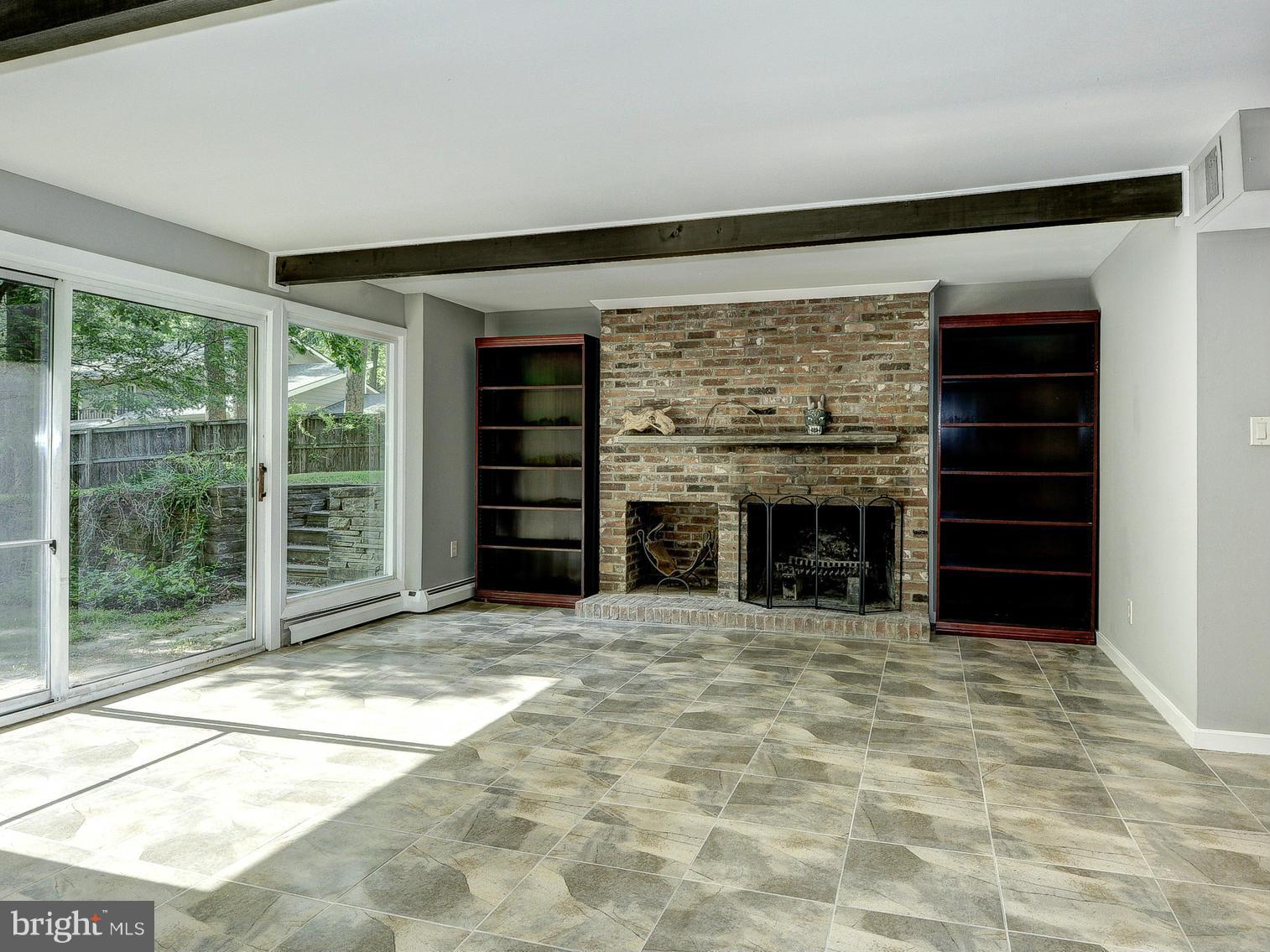 6718 Persimmon Tree Road Bethesda, MD 20817 - Photo 22 of 30 a view of an empty room with a fireplace and a window