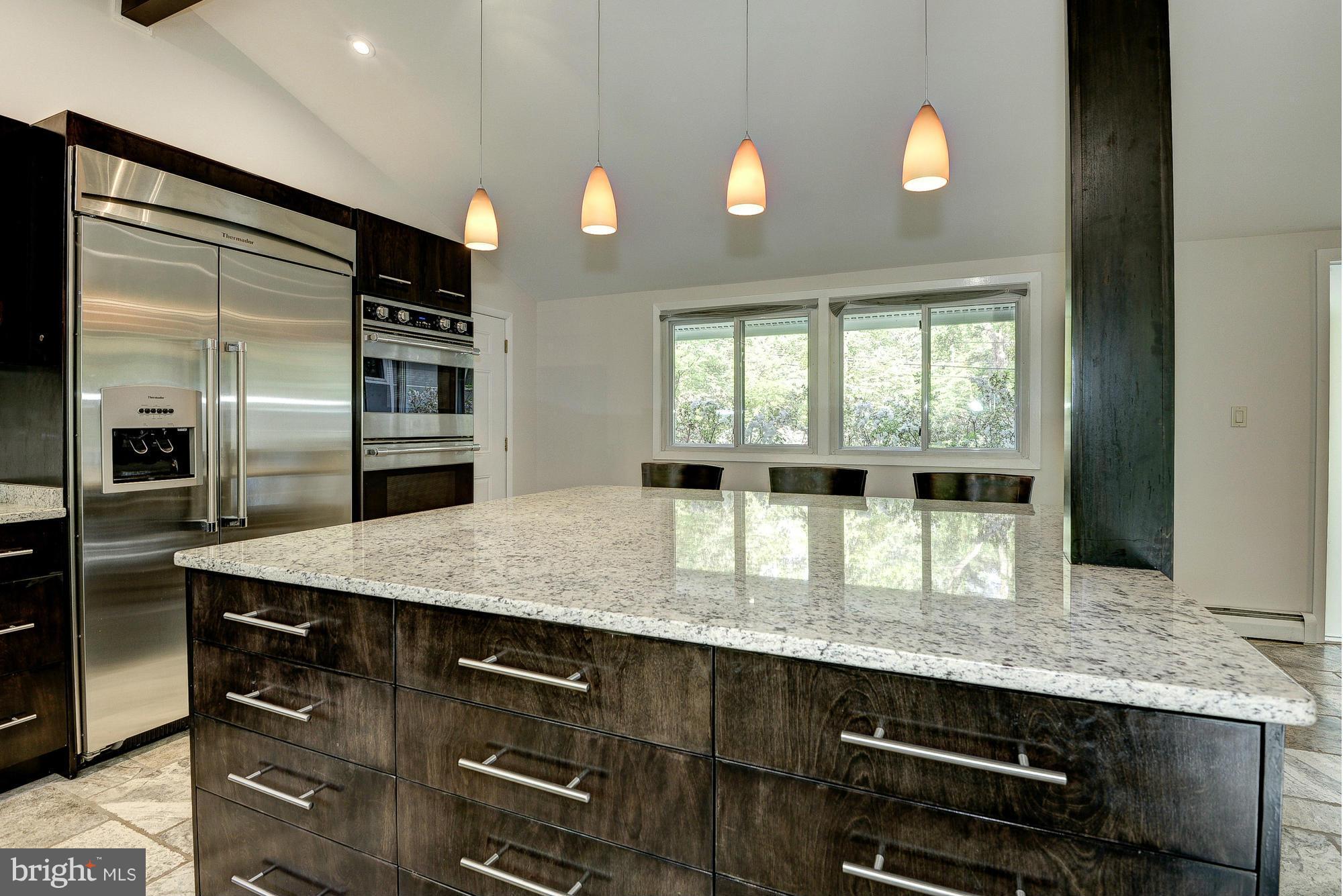 6718 Persimmon Tree Road Bethesda, MD 20817 - Photo 10 of 30 a kitchen with kitchen island granite countertop a sink cabinets and stainless steel appliances