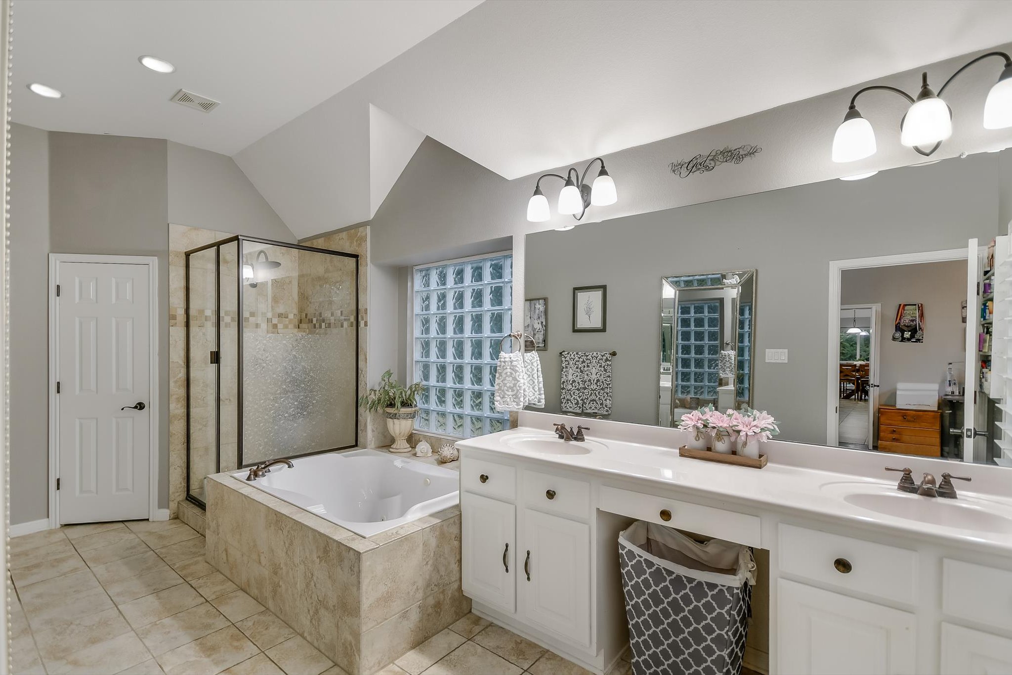 300 Wesley Ridge Drive Spicewood, TX 78669 - Photo 20 of 40 The primary bath offers a spa-like retreat with a luxurious jetted tub, a large walk-in shower, dual vanities, and plenty of natural light from the glass block window.