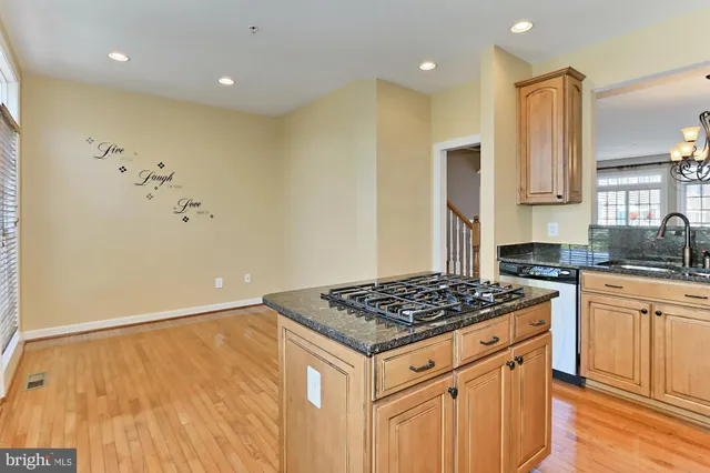 a kitchen with granite countertop stainless steel appliances a stove cabinets and a counter top space