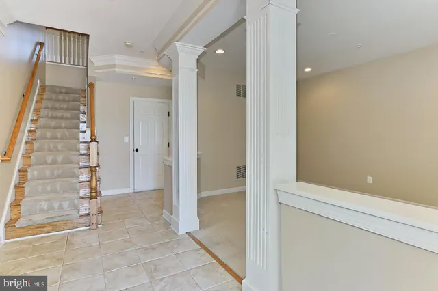 an empty room with windows and entrance to other room