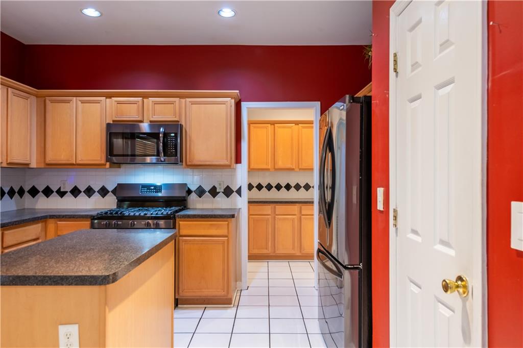 640 Fitzgerald Place Atlanta, GA 30349 - Photo 17 of 46 a kitchen with stainless steel appliances granite countertop a refrigerator and a stove top oven