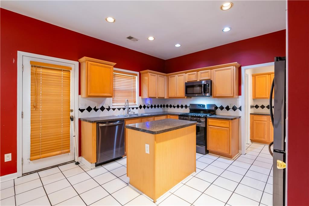 640 Fitzgerald Place Atlanta, GA 30349 - Photo 18 of 46 a kitchen with granite countertop a sink and cabinets
