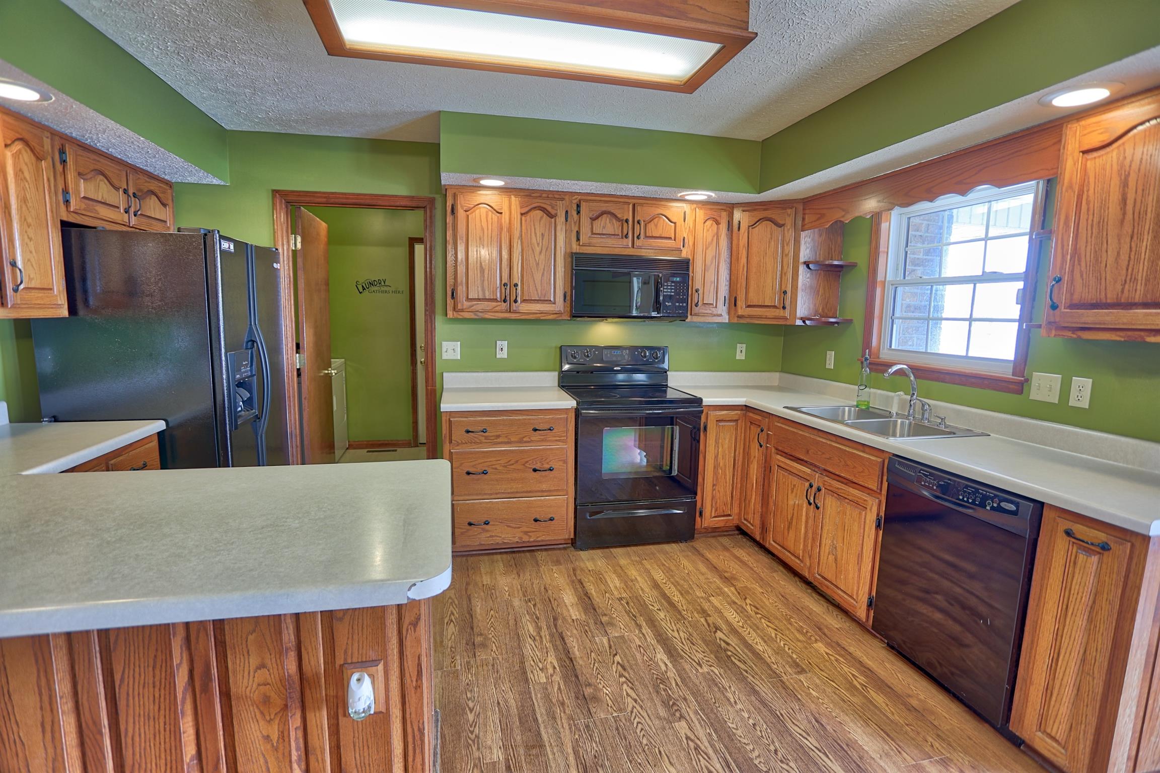 4322 Dot Road Springfield, TN 37172 - Photo 4 of 22 a kitchen with stainless steel appliances kitchen island granite countertop a refrigerator a sink dishwasher a stove and white countertops with wooden floor