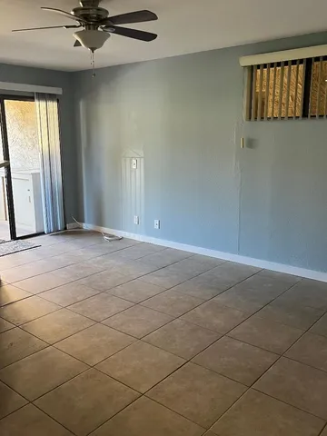 an empty room with window and a ceiling fan