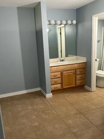 a bathroom with a granite countertop sink and a mirror