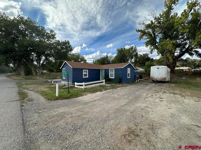 a view of house with backyard and trees