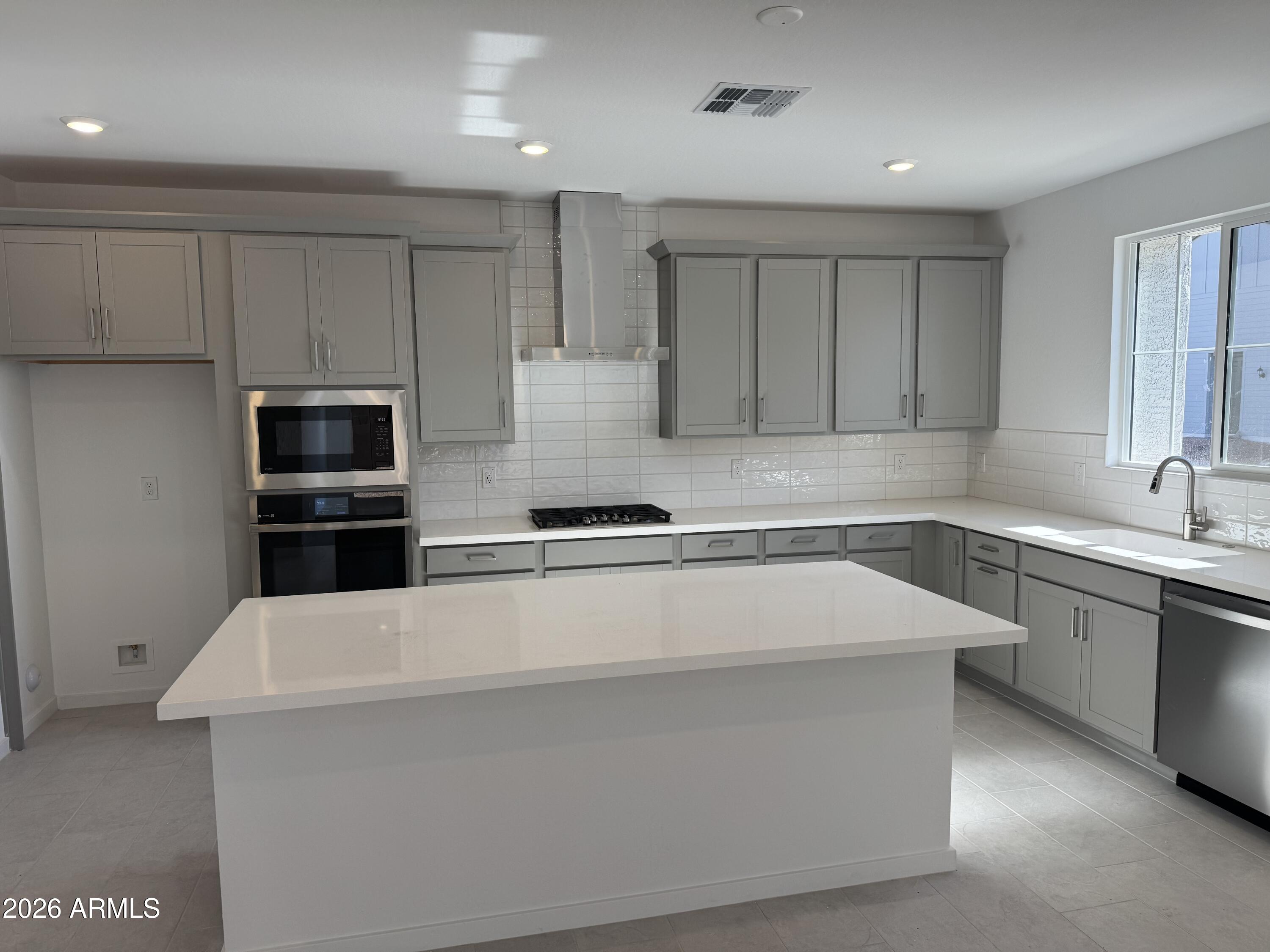 2460 West Maximo Way Phoenix, AZ 85085 - Photo 4 of 14 a large kitchen with stainless steel appliances a large counter top and a stove top oven