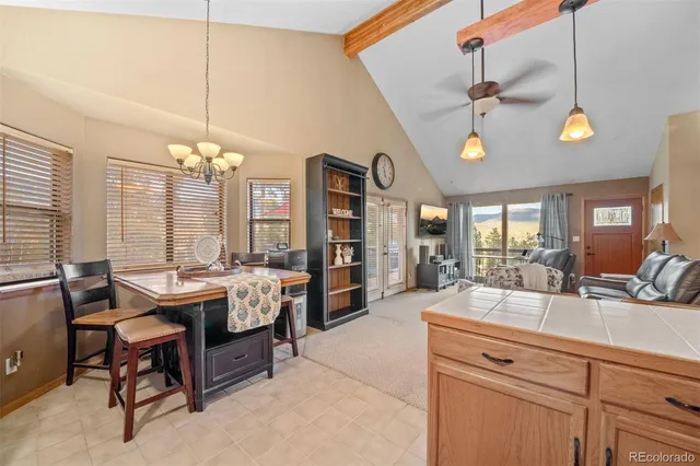 a room with a table chairs and a chandelier