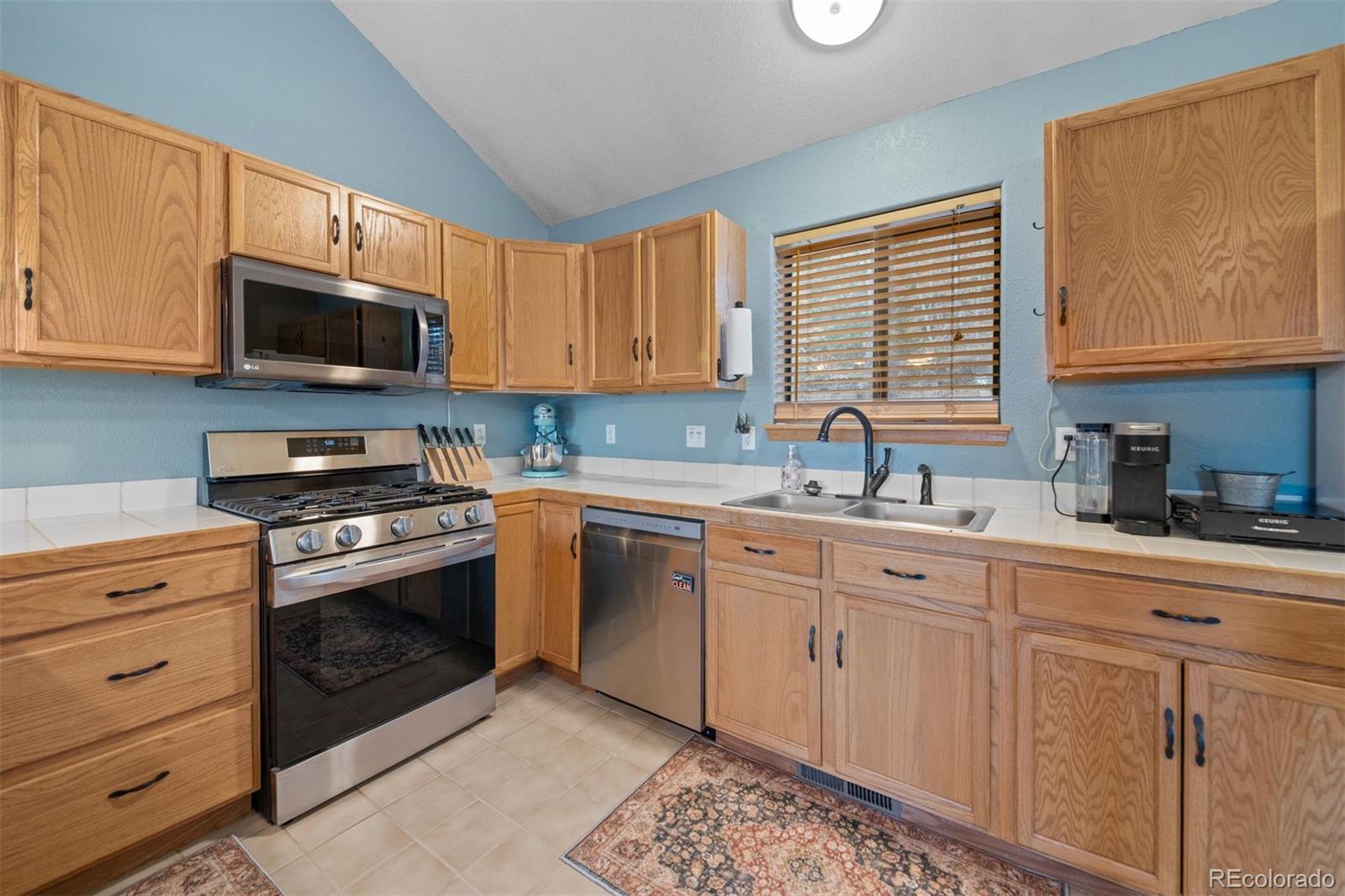 609 Gold Flake Terrace Bailey, CO 80421 - Photo 14 of 47 a kitchen with granite countertop cabinets stainless steel appliances and a window