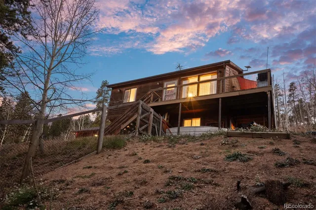 a view of a house with a yard and large tree