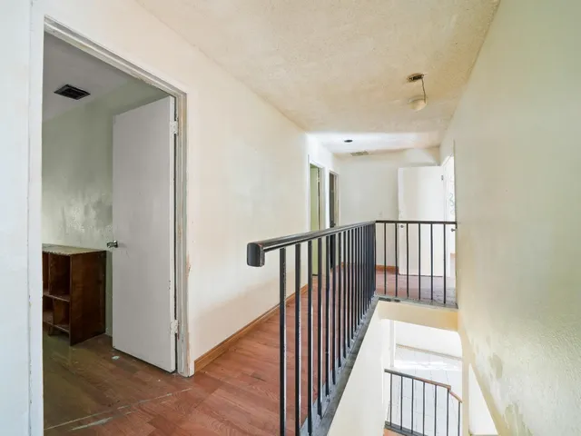 a view of a hallway with wooden floor and windows