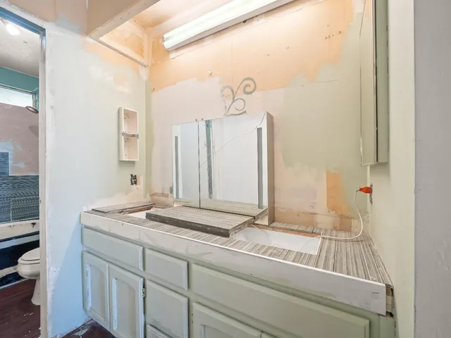 a bathroom with a granite countertop sink and a mirror