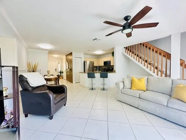 a living room with furniture and a ceiling fan