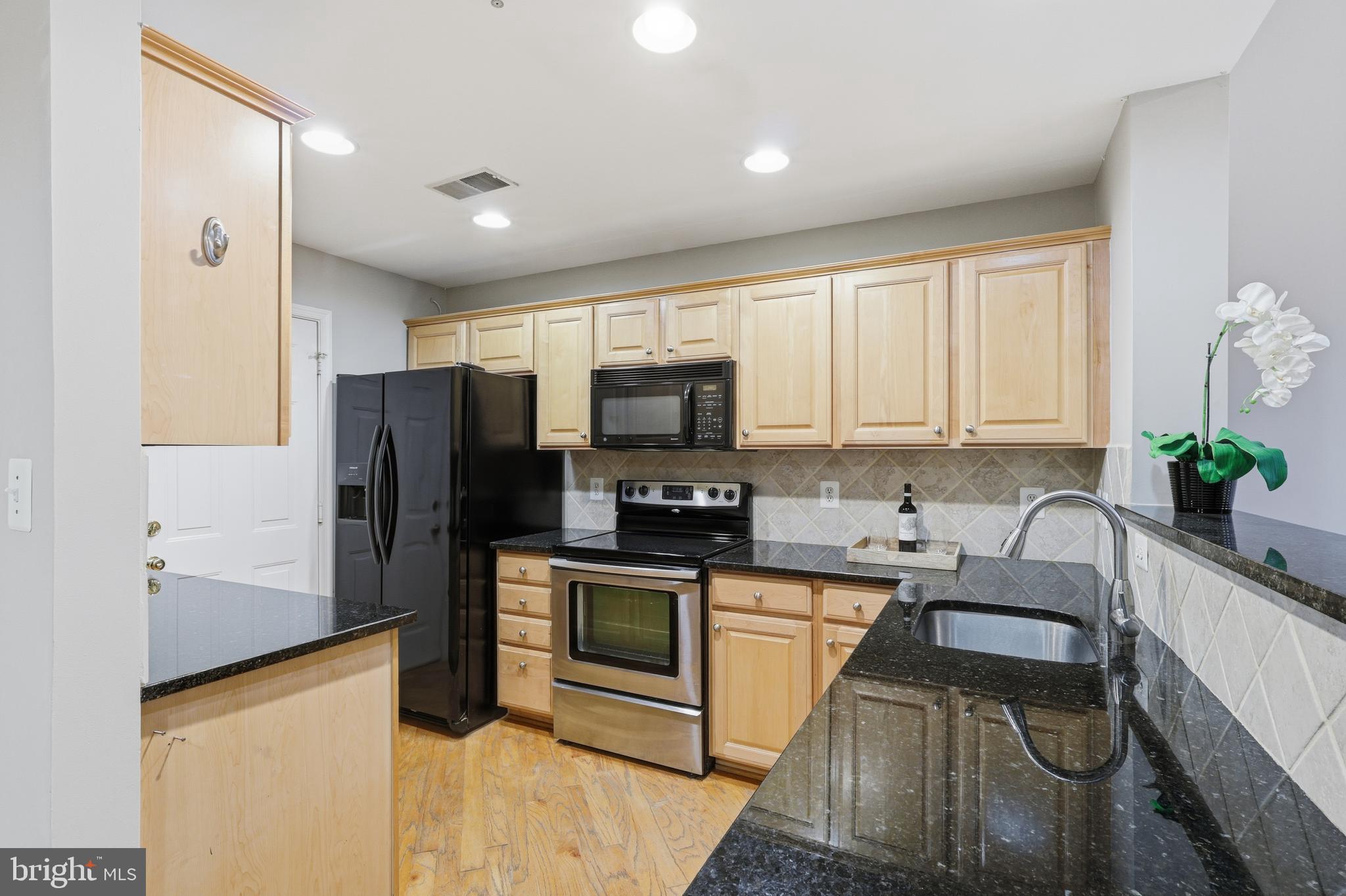 1934 Crescent Park Drive, Unit 28A Reston, VA 20190 - Photo 11 of 38 a kitchen with granite countertop a refrigerator stove and sink
