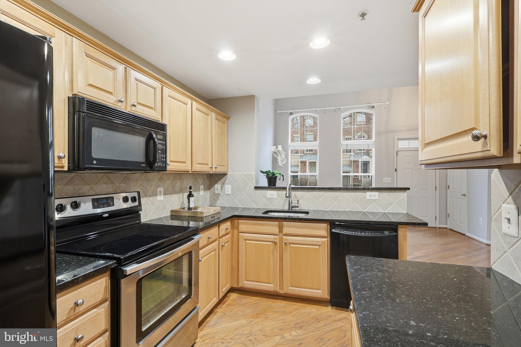 1934 Crescent Park Drive, Unit 28A Reston, VA 20190 - Photo 12 of 38 a kitchen with stainless steel appliances granite countertop a sink stove and microwave