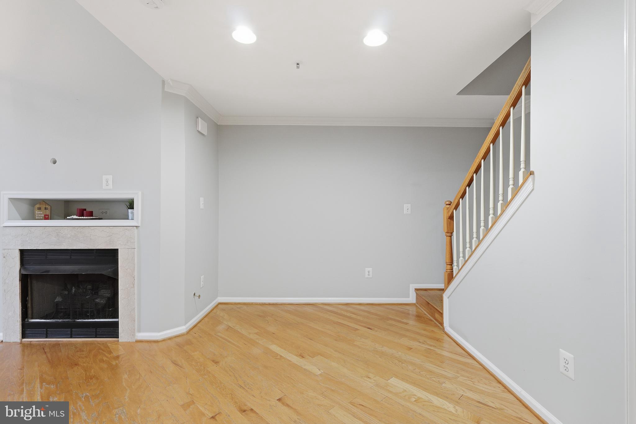 1934 Crescent Park Drive, Unit 28A Reston, VA 20190 - Photo 8 of 38 a view of an empty room with wooden floor and a fireplace