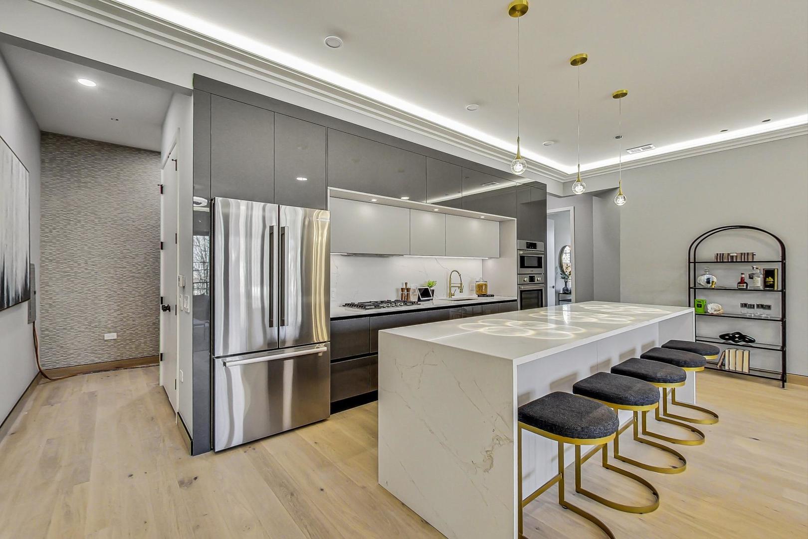 2024 West Irving Park Road, Unit 304 Chicago, IL 60618 - Photo 3 of 12 a kitchen with kitchen island a stove a refrigerator and a dining table with wooden floor