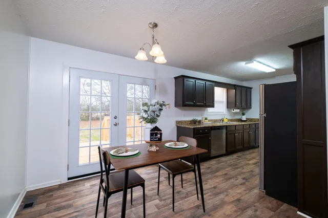 a view of a dining room with furniture a chandelier and wooden floor