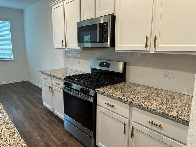 a view of kitchen with kitchen island wooden floors wooden floor and center island