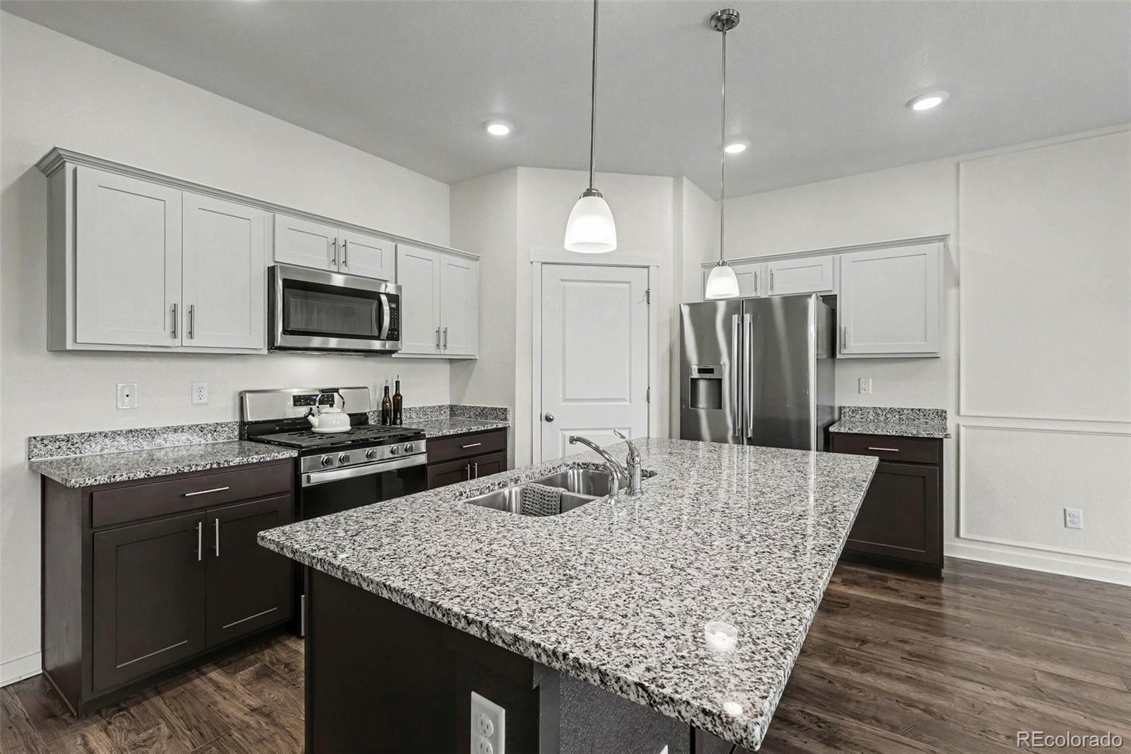2226 Monte Vista Court Fort Lupton, CO 80621 - Photo 11 of 25 a kitchen with kitchen island a counter space a sink appliances and cabinets