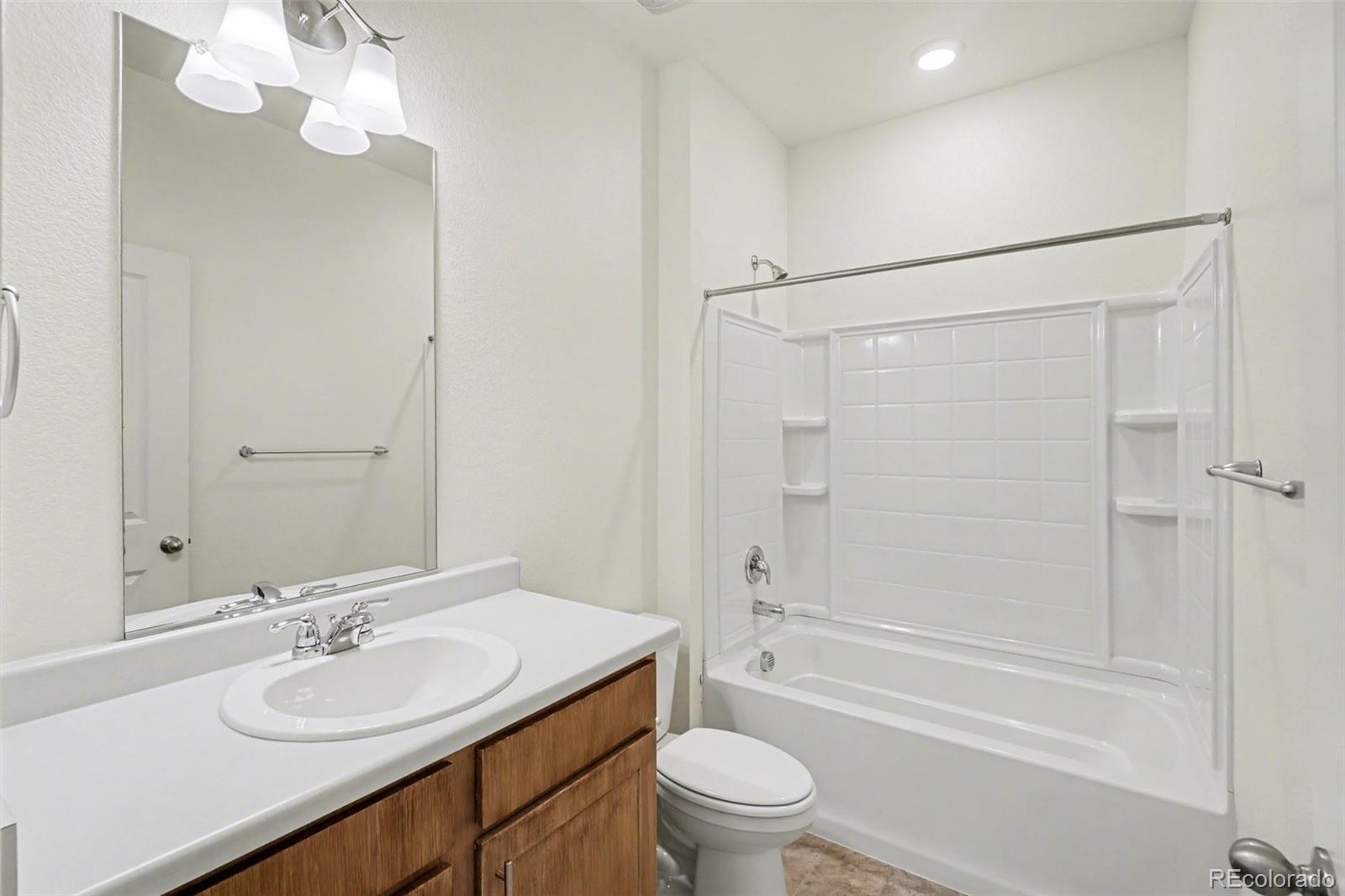 2226 Monte Vista Court Fort Lupton, CO 80621 - Photo 13 of 25 a bathroom with a granite countertop sink a toilet and shower