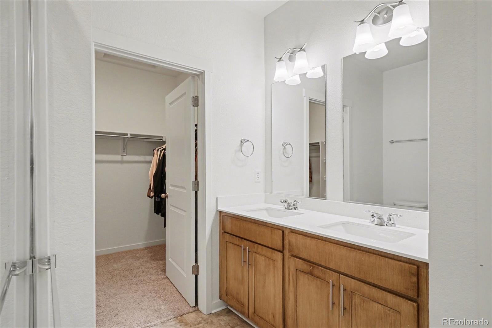2226 Monte Vista Court Fort Lupton, CO 80621 - Photo 19 of 25 a bathroom with a double vanity sink mirror and shower