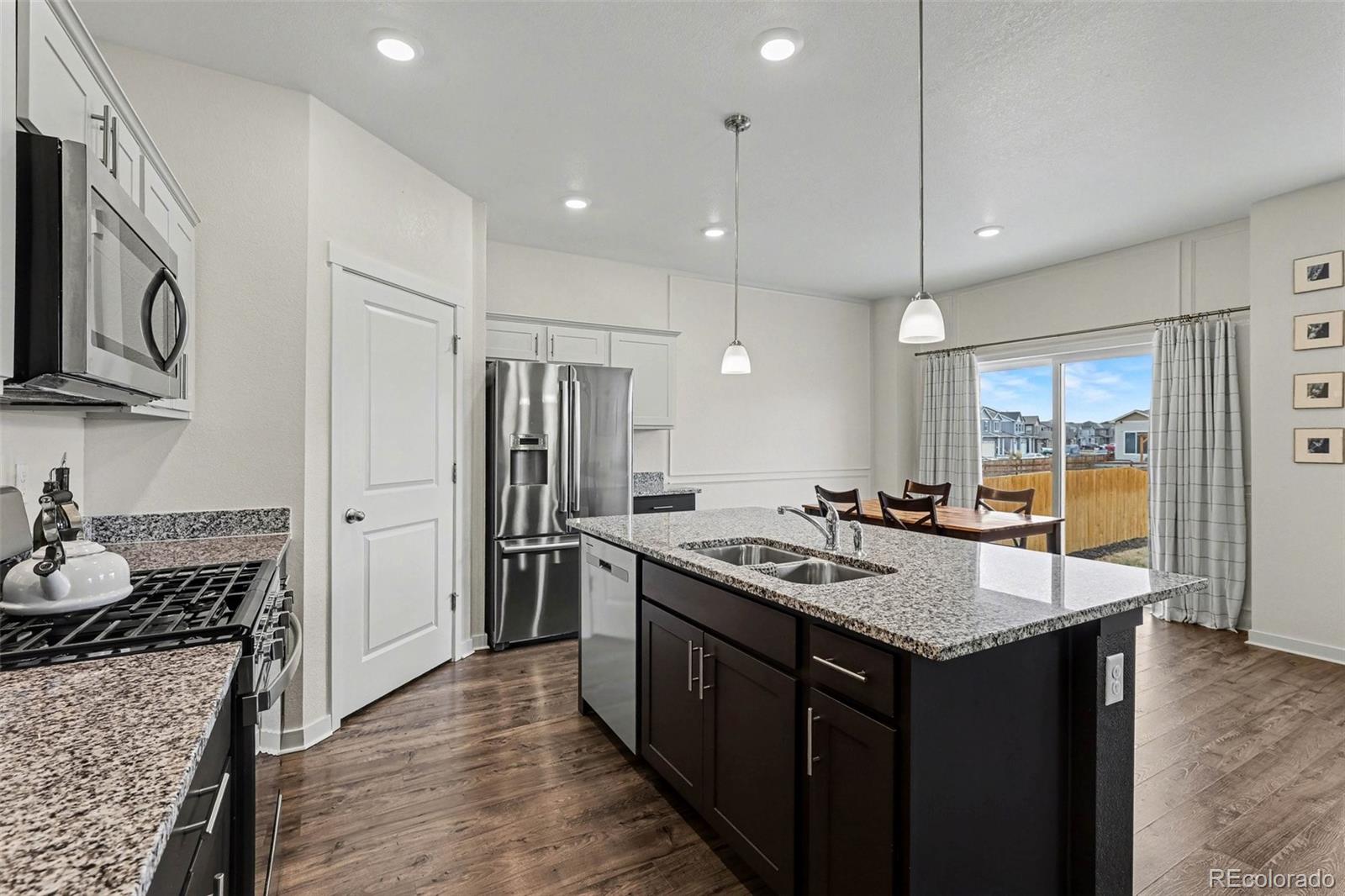 2226 Monte Vista Court Fort Lupton, CO 80621 - Photo 9 of 25 a kitchen with a stove and a wooden floor