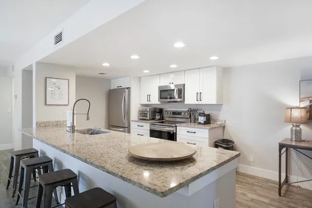 a kitchen with stainless steel appliances granite countertop a sink stove and refrigerator