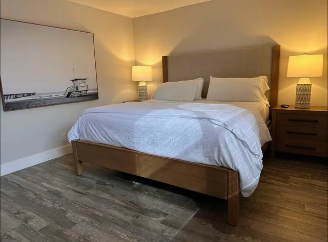 a bedroom with a bed and wooden floor