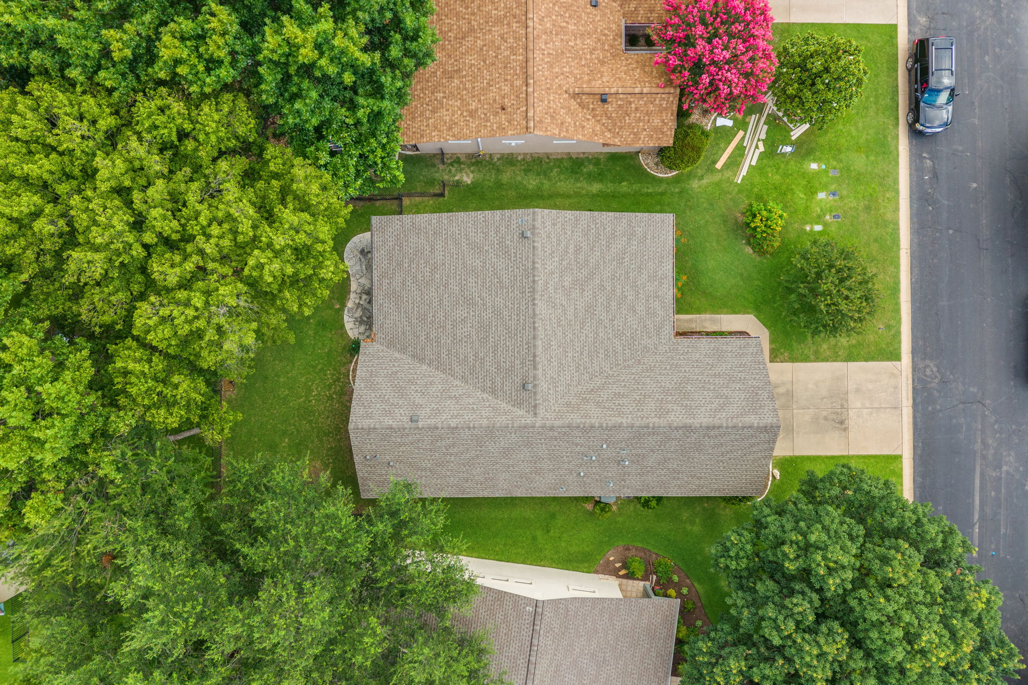 118 Bass Street Georgetown, TX 78633 - Photo 6 of 40 An aerial perspective reveals a well-maintained roof amidst lush landscaping and a concrete driveway.