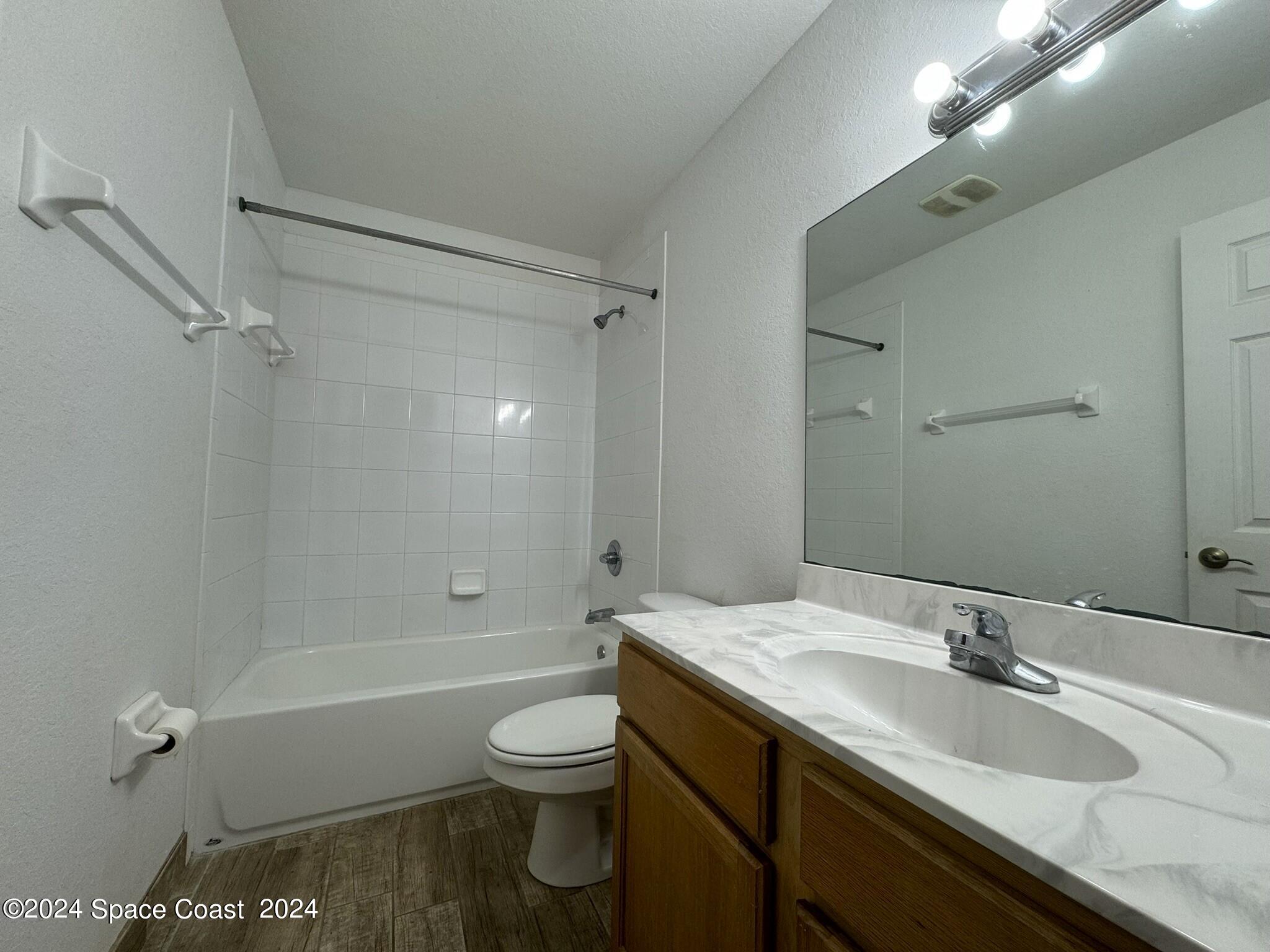 3975 Almeida Court, Unit 105 Melbourne, FL 32901 - Photo 11 of 18 a bathroom with a granite countertop sink toilet and shower