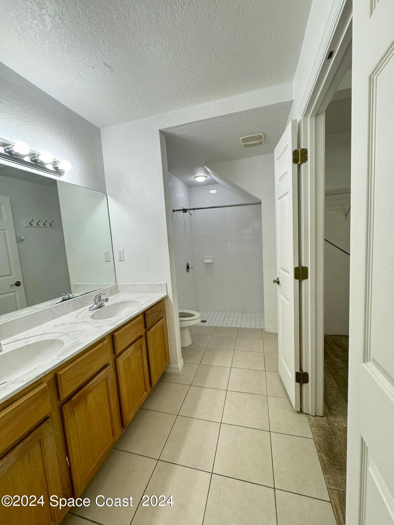 3975 Almeida Court, Unit 105 Melbourne, FL 32901 - Photo 6 of 18 a bathroom with a mirror sink and shower