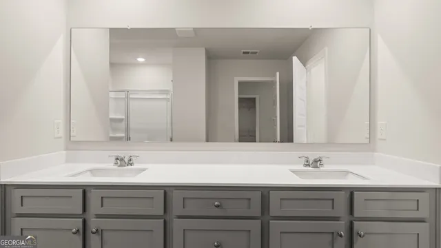a bathroom with a double vanity sink and a mirror