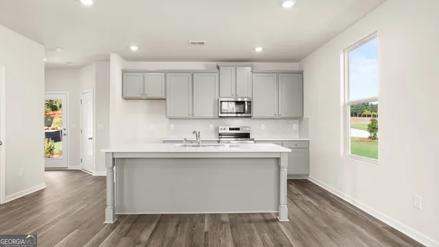 a kitchen with stainless steel appliances granite countertop a sink a stove and a microwave