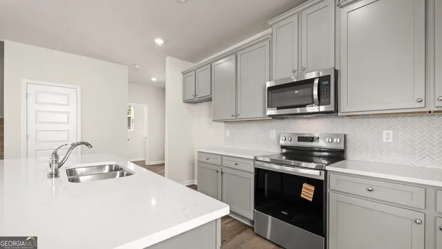 a kitchen with stainless steel appliances a sink stove and cabinets