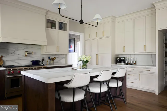 a kitchen with stainless steel appliances a table and chairs in it