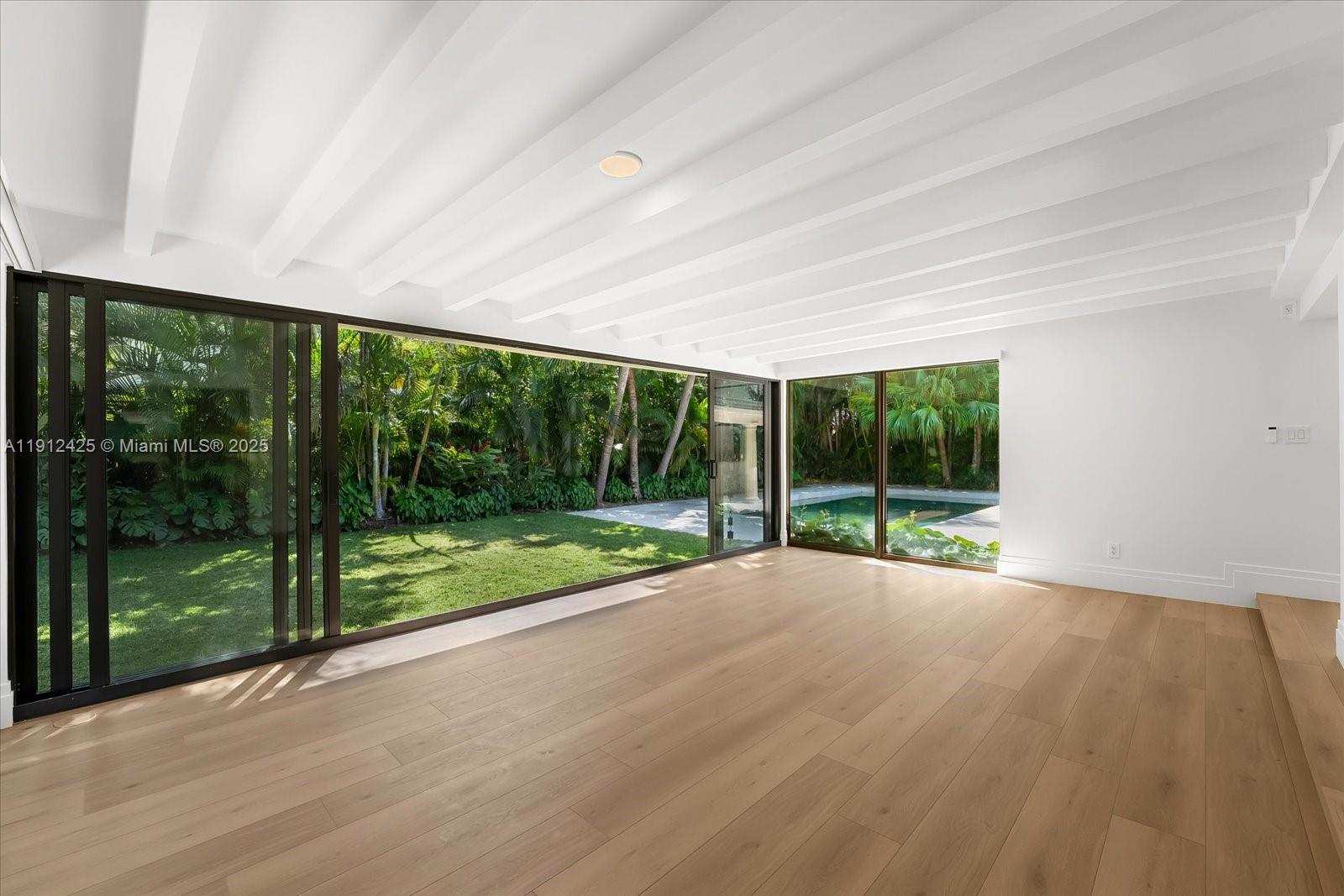 325 Gulf Road Key Biscayne, FL 33149 - Photo 17 of 51 a view of an empty room with wooden floor and a floor to ceiling window