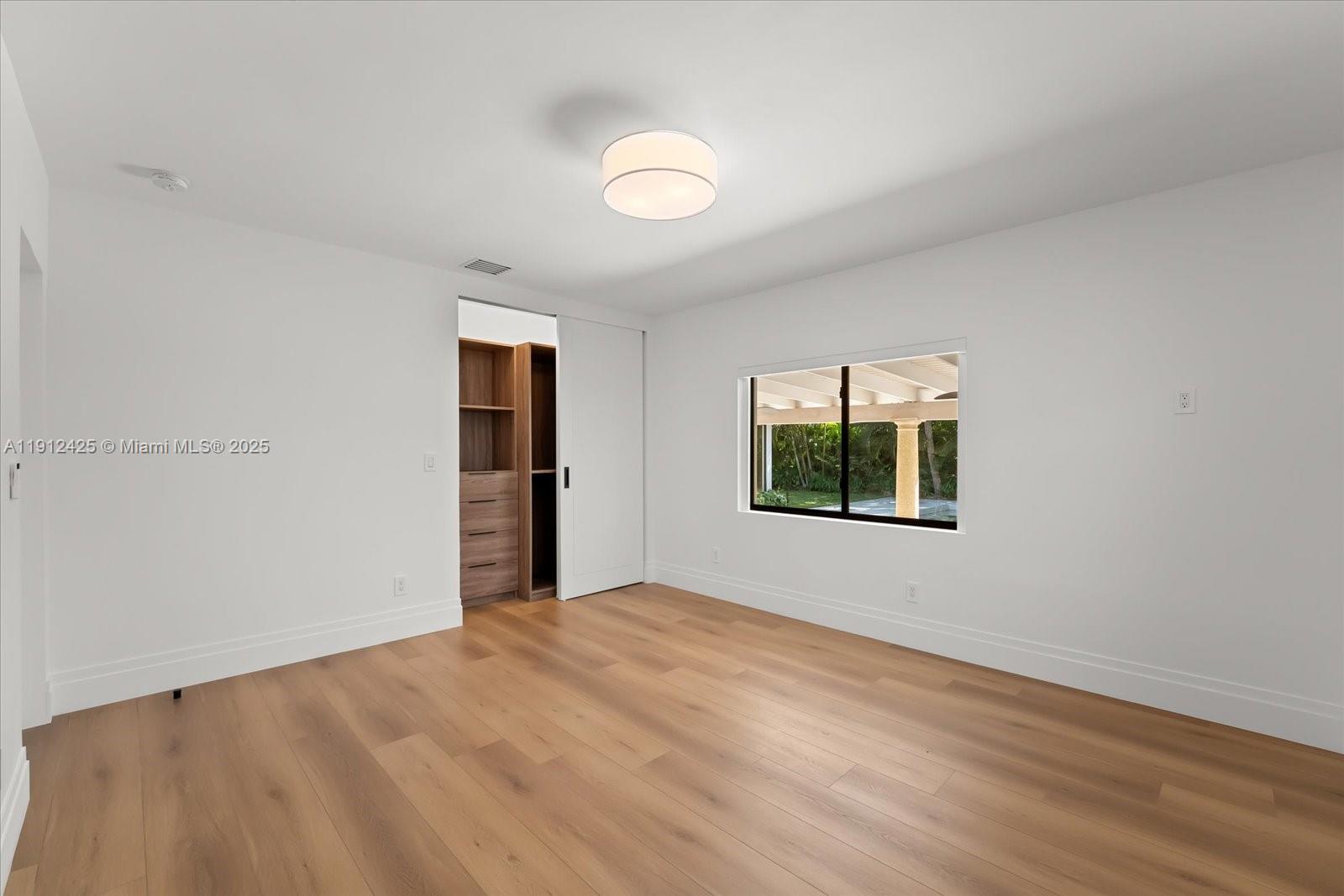 325 Gulf Road Key Biscayne, FL 33149 - Photo 35 of 51 a view of an empty room with wooden floor and a window