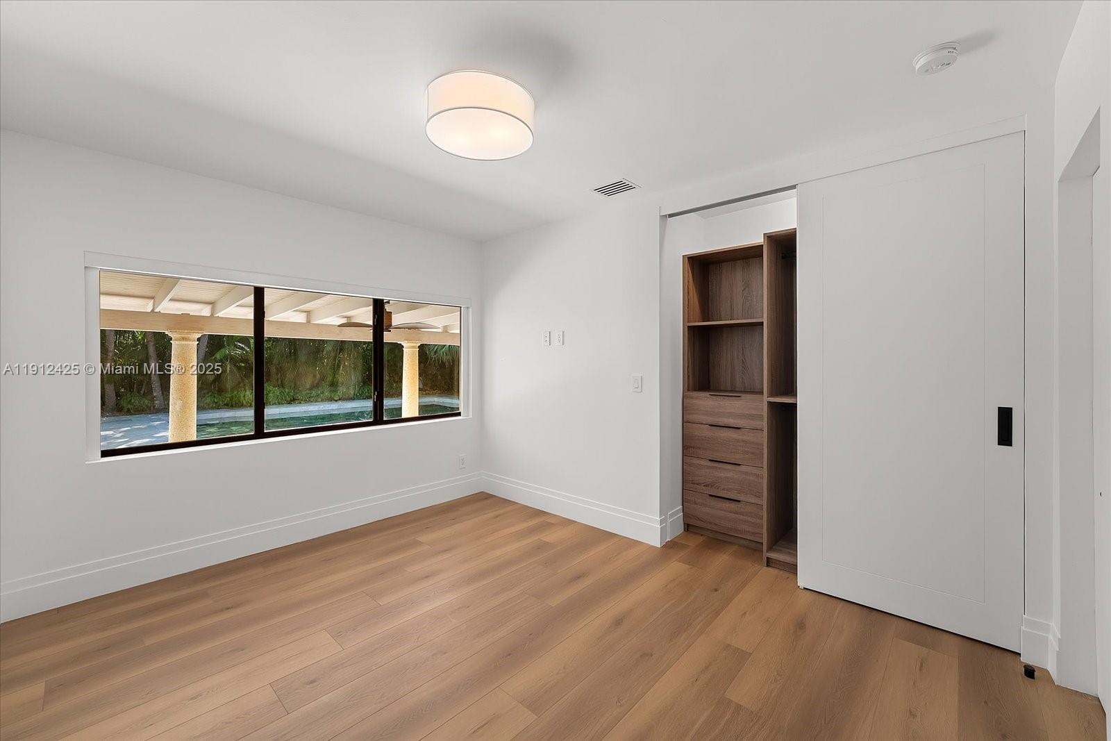 325 Gulf Road Key Biscayne, FL 33149 - Photo 36 of 51 a view of an empty room with a window and wooden floor