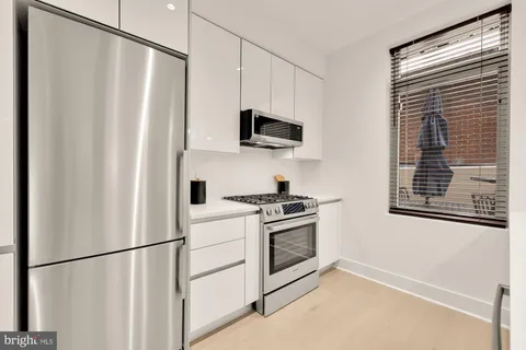 a view of kitchen with stainless steel appliances granite countertop a refrigerator and a stove top oven